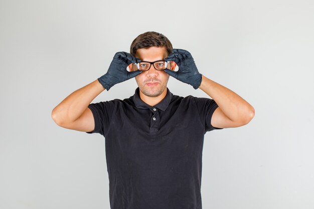 Hombre en camisa polo negra ponerse gafas