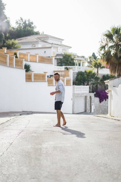 Un hombre con una camisa a rayas, camina por las calles de un pequeño pueblo español.