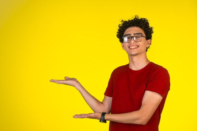 Hombre de camisa roja haciendo presentación con gestos con las manos y sonriendo