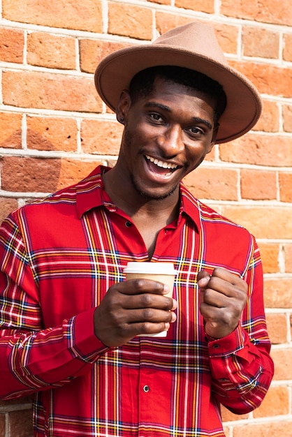 Foto gratuita hombre de camisa roja sonríe y sosteniendo café