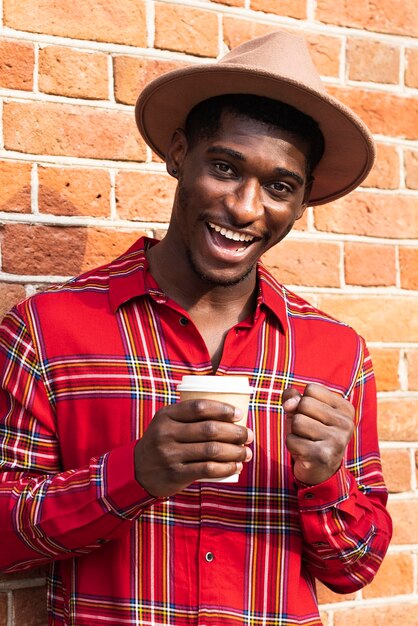 Hombre de camisa roja sonríe y sosteniendo café