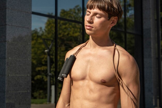 Hombre sin camisa con saltar la cuerda al aire libre