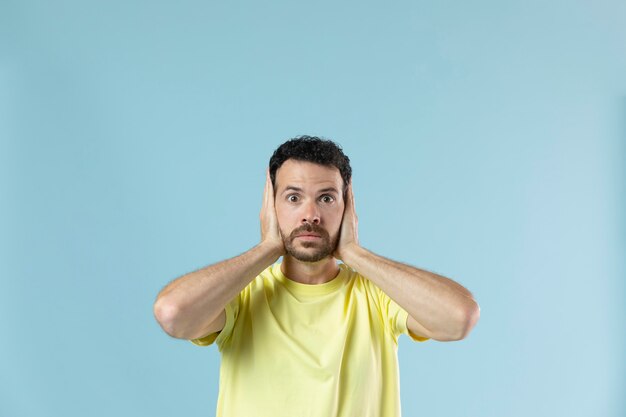 Hombre de camiseta amarilla posando para un retrato de estudio