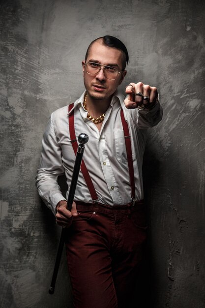 Hombre con camiseta blanca, pantalones rojos y gafas.