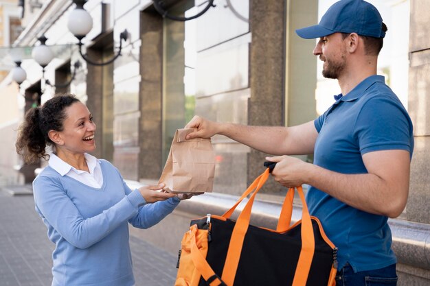 Hombre en camiseta entregando comida para llevar