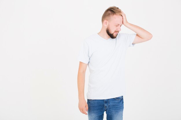 Hombre en camiseta sufriendo de dolor de cabeza.