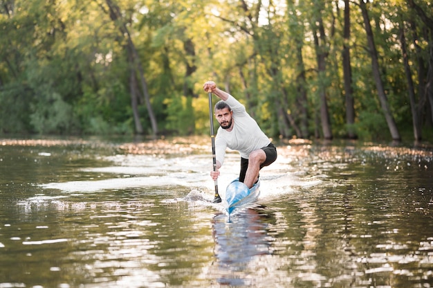 Hombre en canoa remando tiro largo