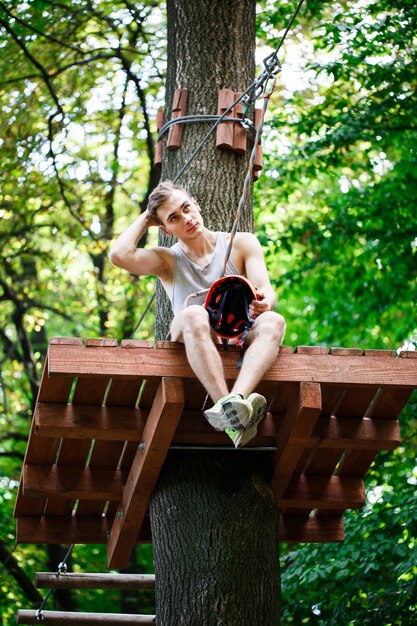 Hombre cansado se sienta en el árbol