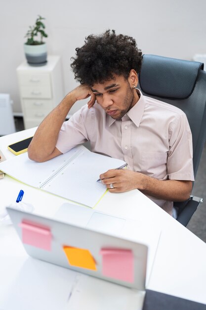 Hombre cansado de tiro medio tomando notas