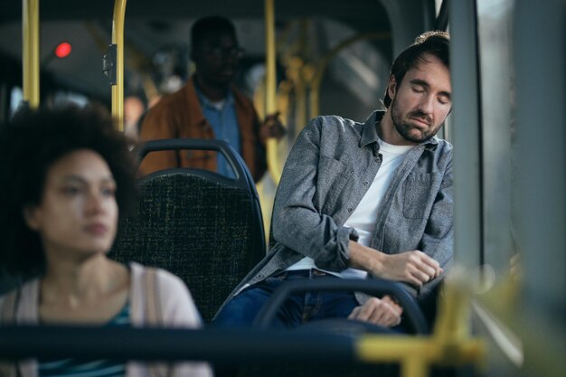 Hombre cansado tomando una siesta mientras viaja en autobús