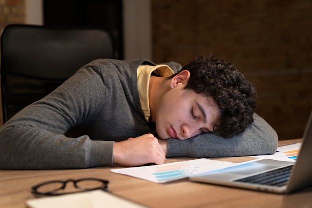 Hombre cansado trabajando hasta tarde en la oficina