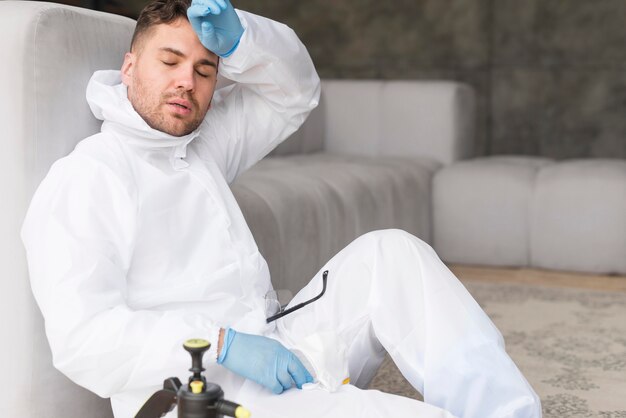 Hombre cansado en traje de protección