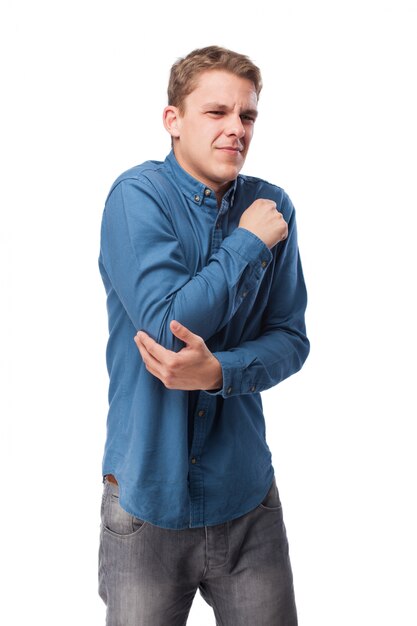 Hombre con cara de dolor tocándose el codo