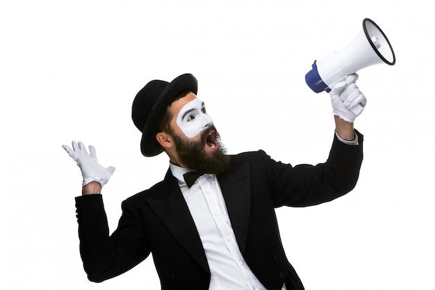 Hombre con una cara mime gritando por megáfono