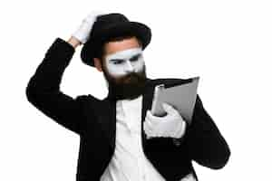 Foto gratuita hombre con una cara mime trabajando en la computadora portátil