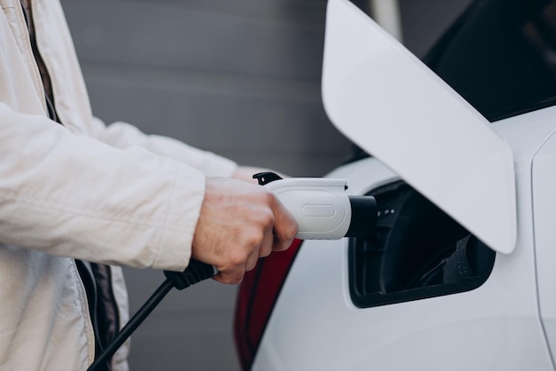 Hombre cargando auto eléctrico por la casa