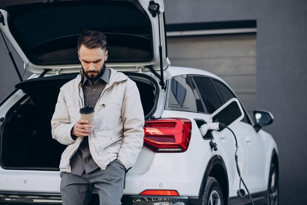 Hombre cargando auto eléctrico por la casa