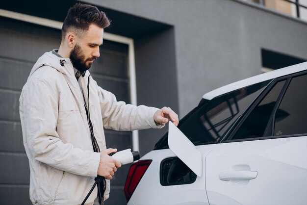 Hombre cargando auto eléctrico por la casa