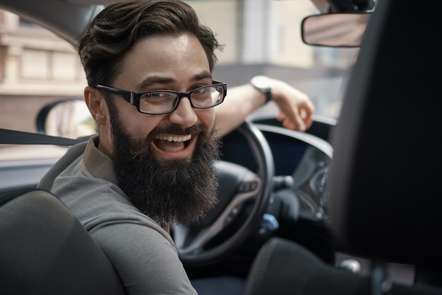 Hombre carismático feliz conduciendo un automóvil