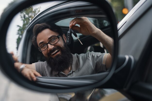 Hombre carismático que sostiene las llaves del auto