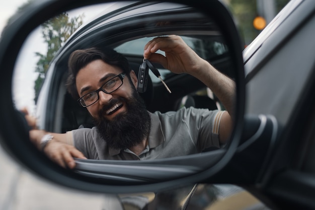 Hombre carismático que sostiene las llaves del auto