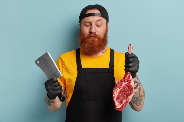 Hombre carnicero con barba de jengibre con carne