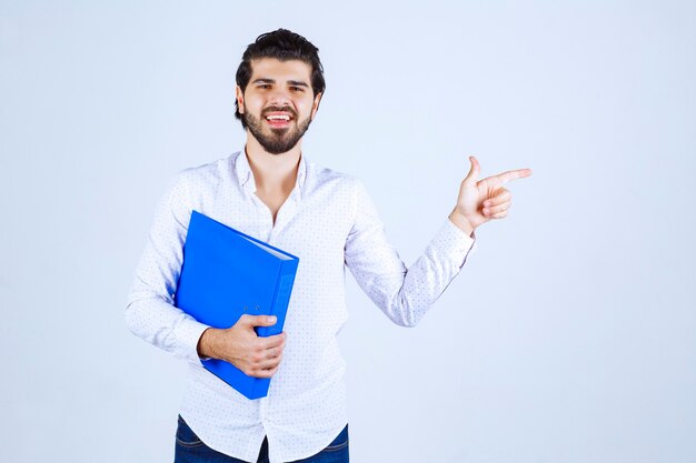 Hombre con una carpeta azul apuntando a la derecha