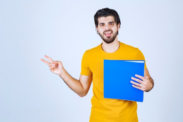 Hombre con carpeta azul dando poses amistosas y pacíficas.