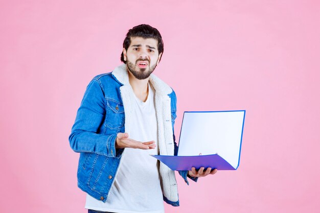 El hombre con una carpeta azul parece aterrorizado y cansado