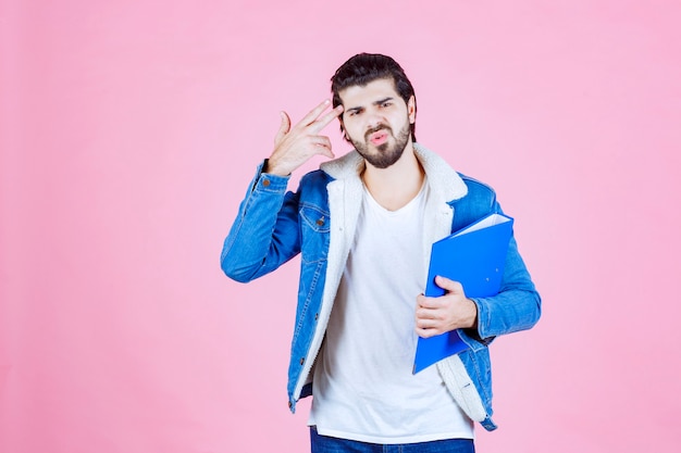 El hombre con una carpeta azul parece aterrorizado y cansado