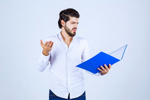 El hombre con una carpeta azul parece exhausto e insatisfecho