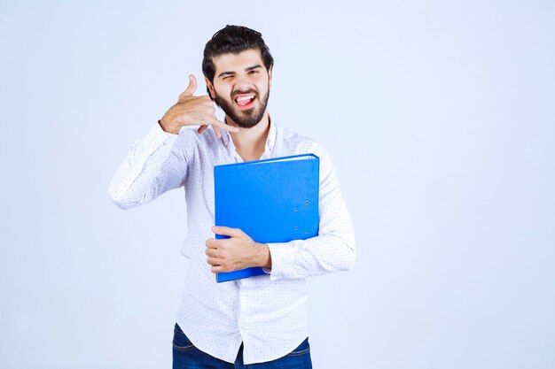 Hombre con una carpeta azul pidiendo llamar