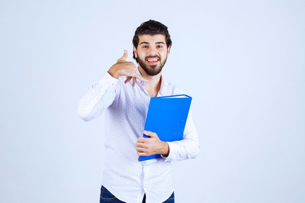 Hombre con una carpeta azul pidiendo llamar