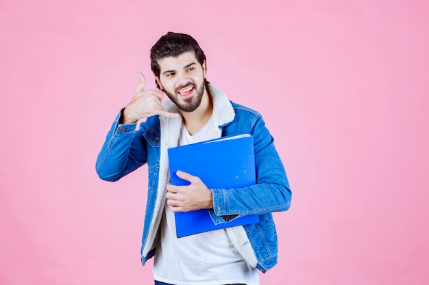 Hombre con una carpeta azul pidiendo llamar