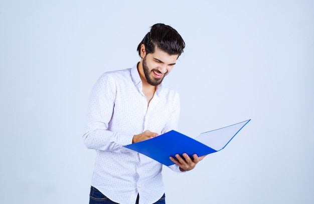 Foto gratuita el hombre con una carpeta azul se siente exitoso