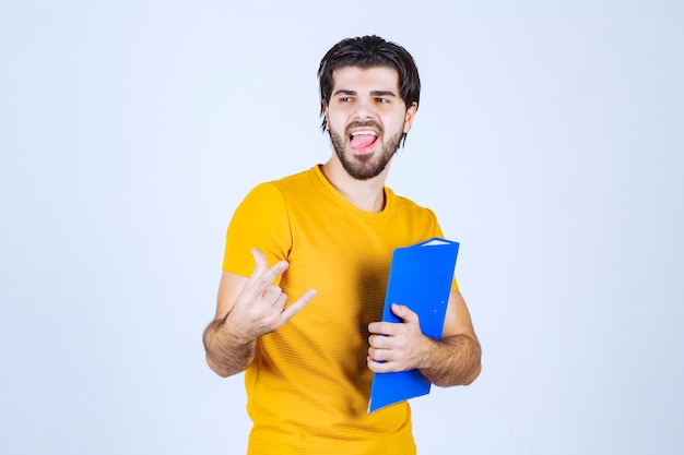 Foto gratuita hombre con carpeta azul sintiéndose bien.