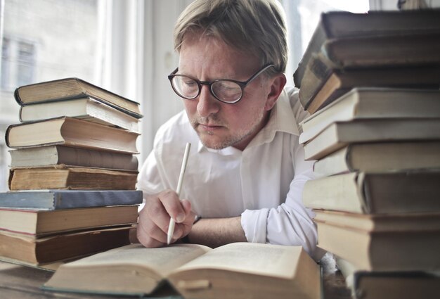 Hombre en casa con libros estudiando