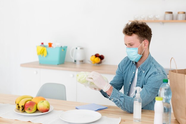 Hombre en casa con mascarilla de limpieza