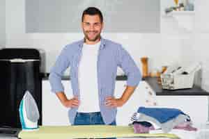 Foto gratuita hombre en casa preparándose para planchar ropa