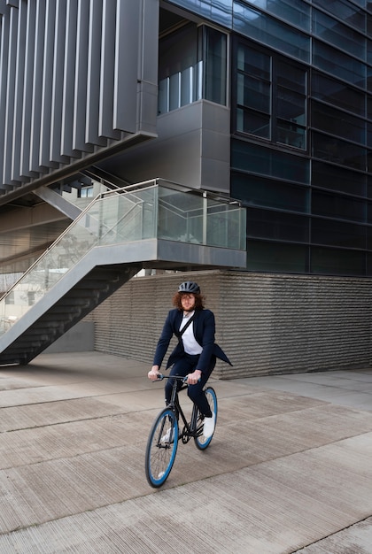 Hombre con casco en bicicleta al trabajo tiro completo