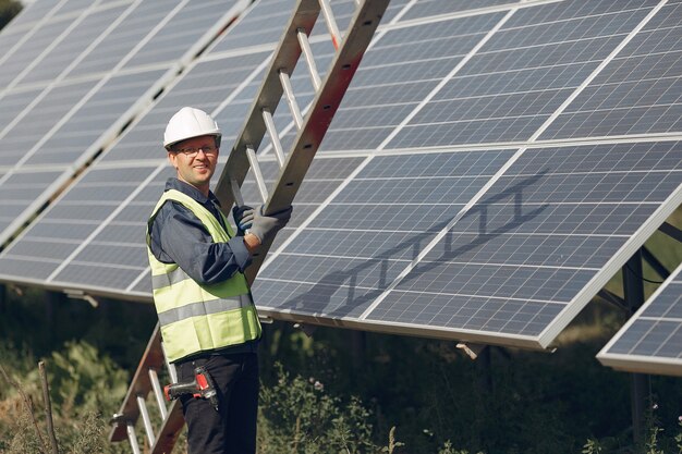 Hombre con casco blanco cerca de un panel solar