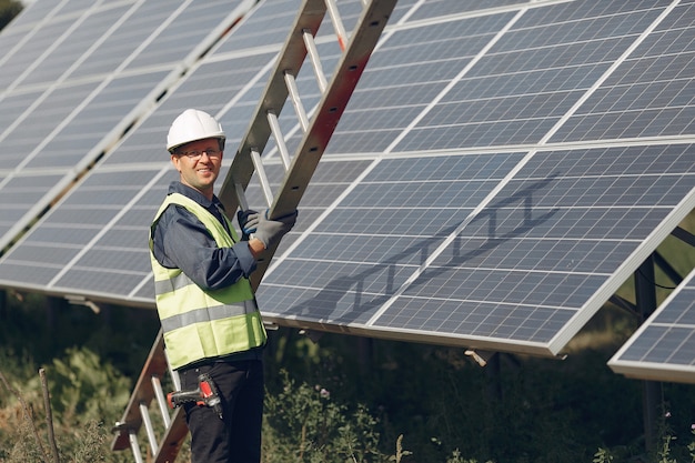 Hombre con casco blanco cerca de un panel solar