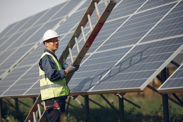 Hombre con casco blanco cerca de un panel solar