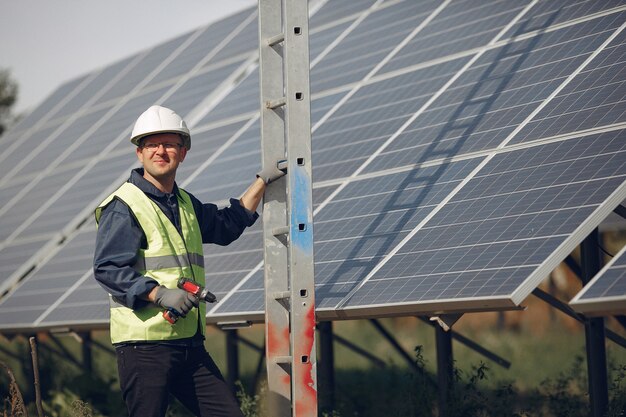 Hombre con casco blanco cerca de un panel solar