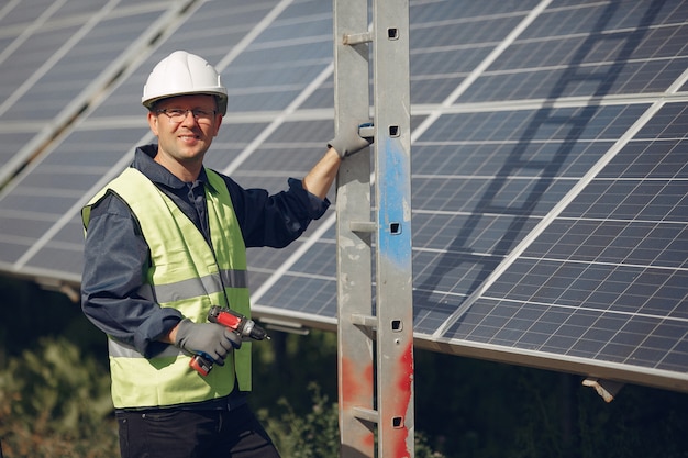 Hombre con casco blanco cerca de un panel solar