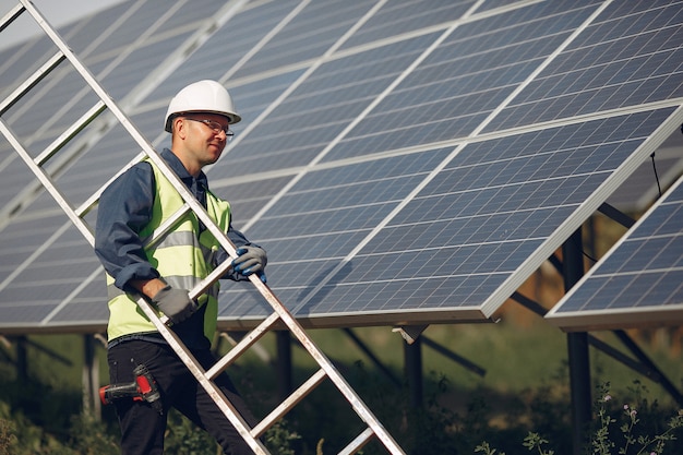 Hombre con casco blanco cerca de un panel solar