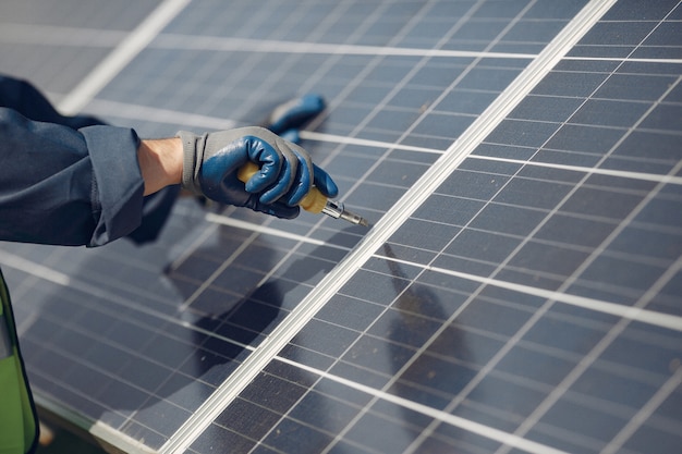 Hombre con casco blanco cerca de un panel solar