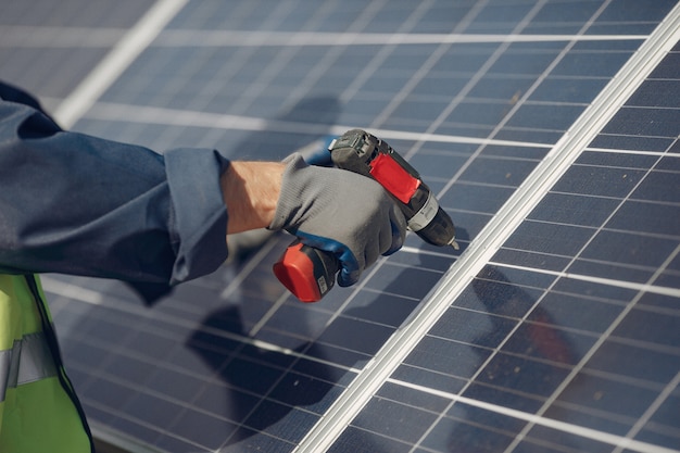 Hombre con casco blanco cerca de un panel solar