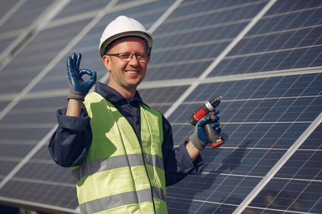 Hombre con casco blanco cerca de un panel solar