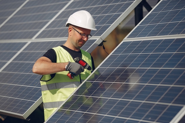 Hombre con casco blanco cerca de un panel solar